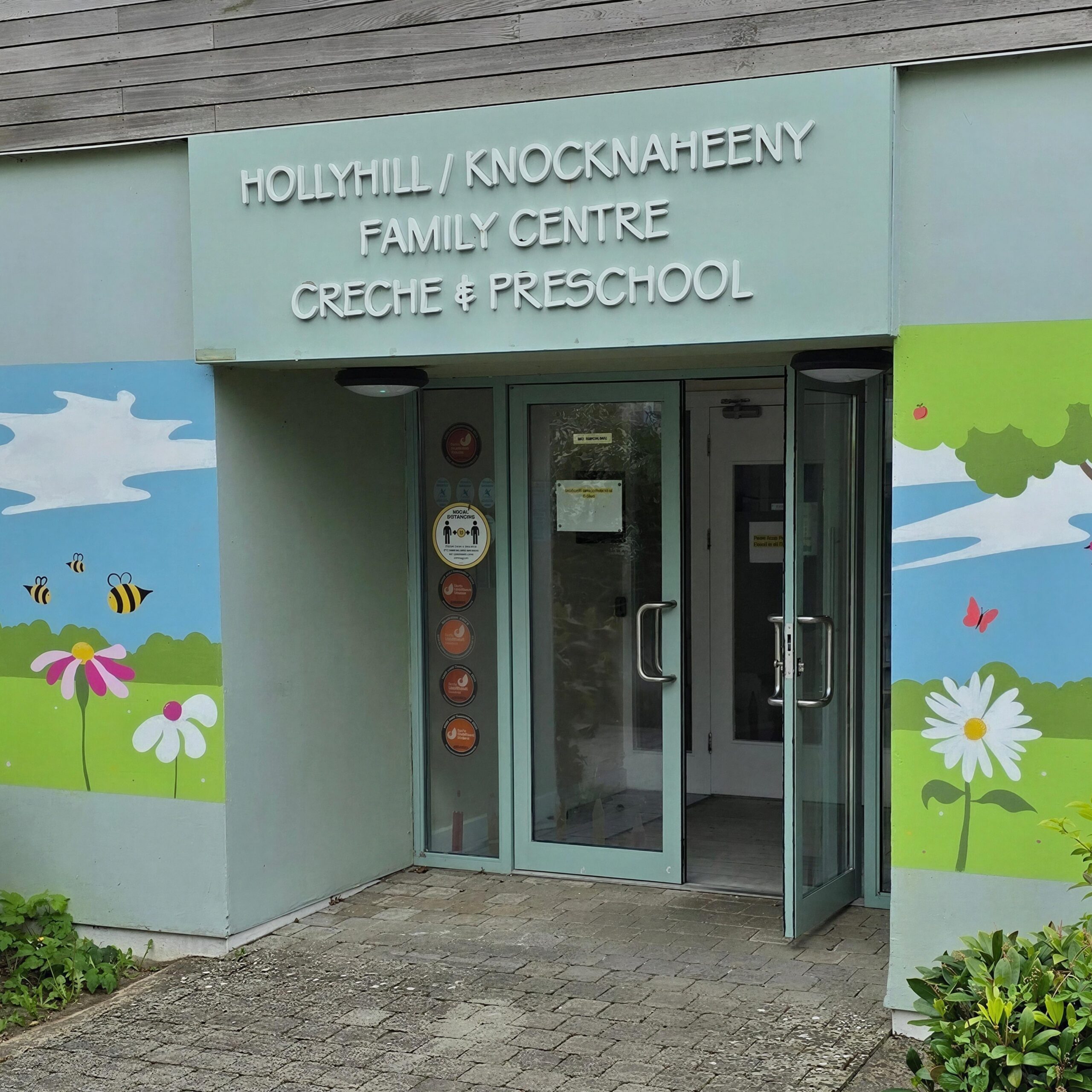Entrance of Hollyhill/Knocknaheeny Family Centre with colorful murals.